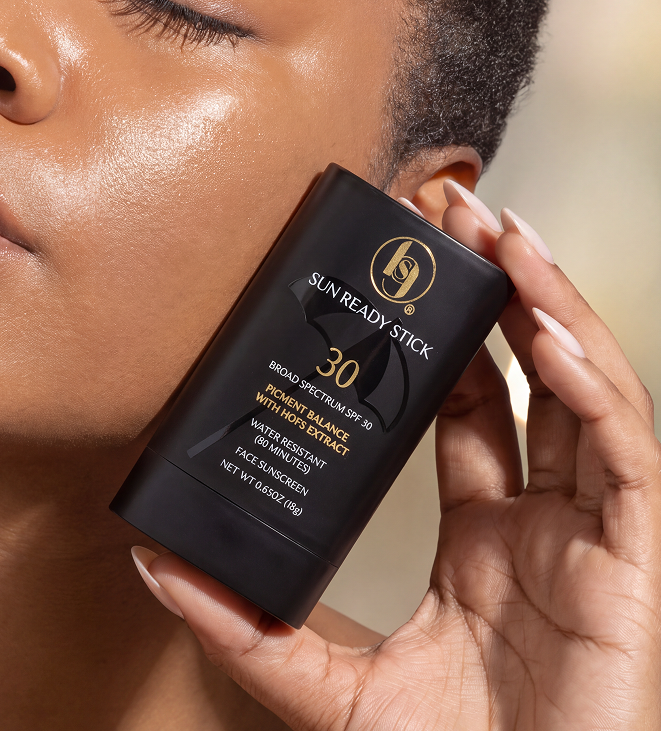 Black Girl Sunscreen sun ready stick packaging held near a model's face